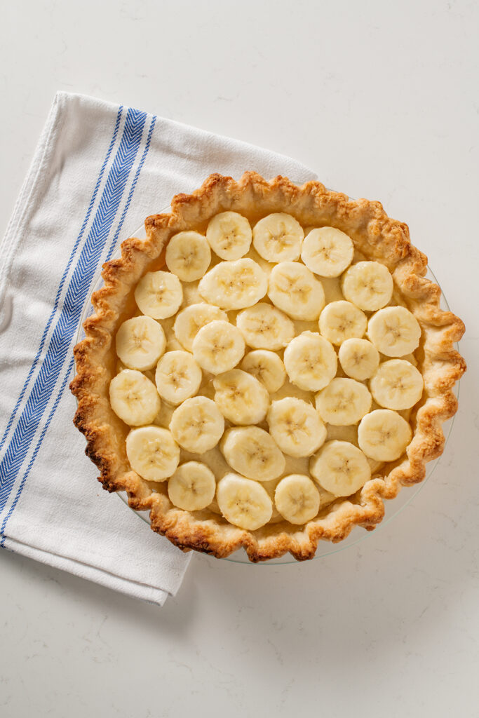 Overhead shot of banana slices on top of filling for Banana Cream Pie.