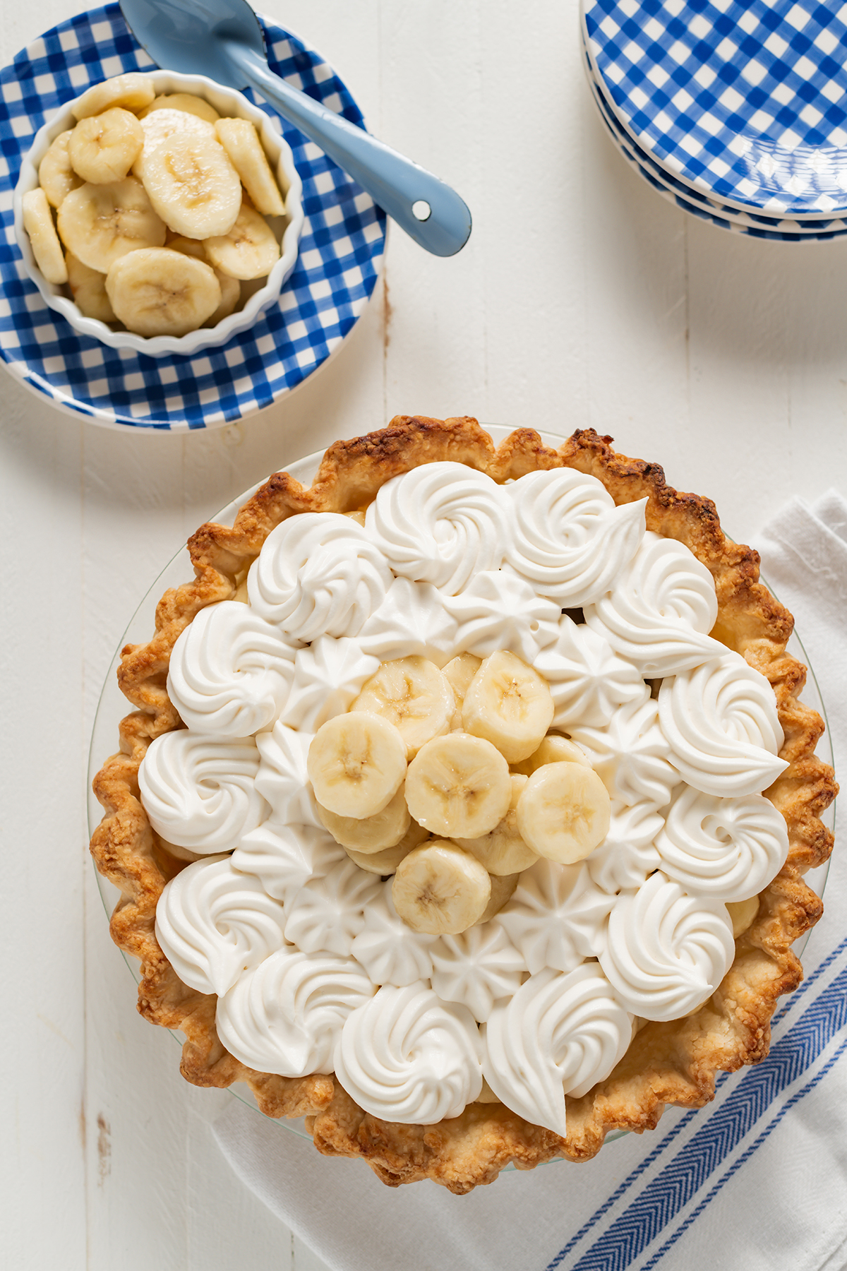 Overhead shot of Banana Cream Pie with white and blue striped towel.