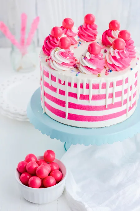 Bubble Gum Layer Cake on cake pedestal at three quarter angle.