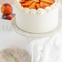 Peaches and Cream Layer Cake at a three-quarter angle on cake pedestal.