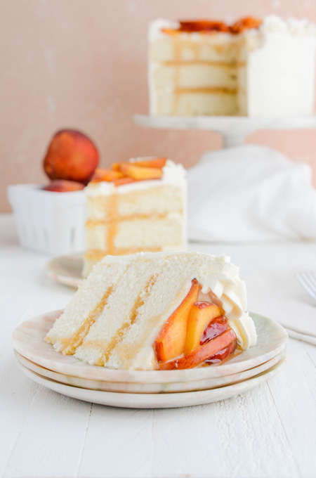 Peaches and Cream Layer Cake with sliced cake on its side.