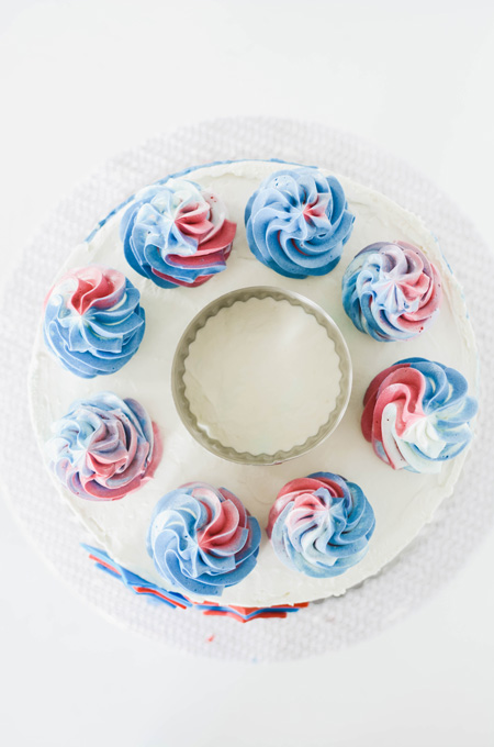 Stars and Stripes Vanilla Cake overhead shot of how to apply sprinkles to the center of the cake with round cutter.