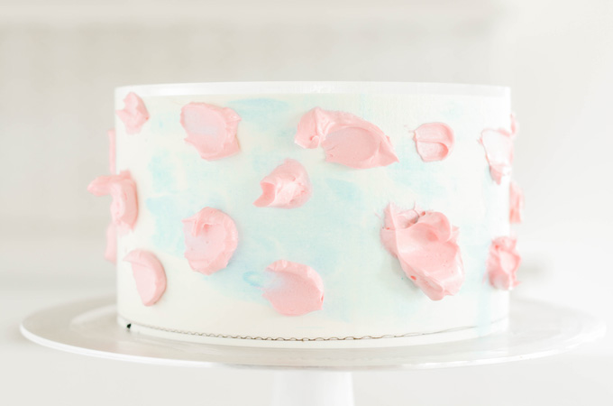 Cotton Candy Layer Cake pink dabs of buttercream on blue scraped cake.