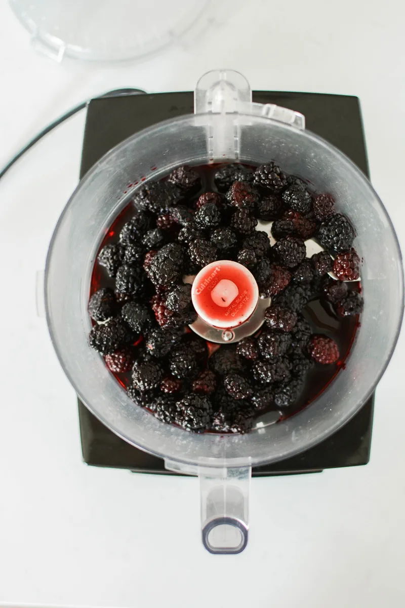 Lime Cake with Blackberry Filling overhead shot of thawed blackberries in food processor.