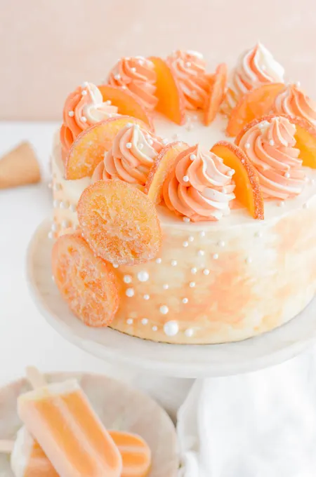 Orange Creamsicle Layer Cake three quarter angle from the top on cake pedestal.