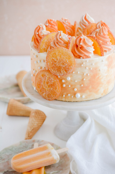Orange Creamsicle Layer Cake three quarter angle on cake pedestal.