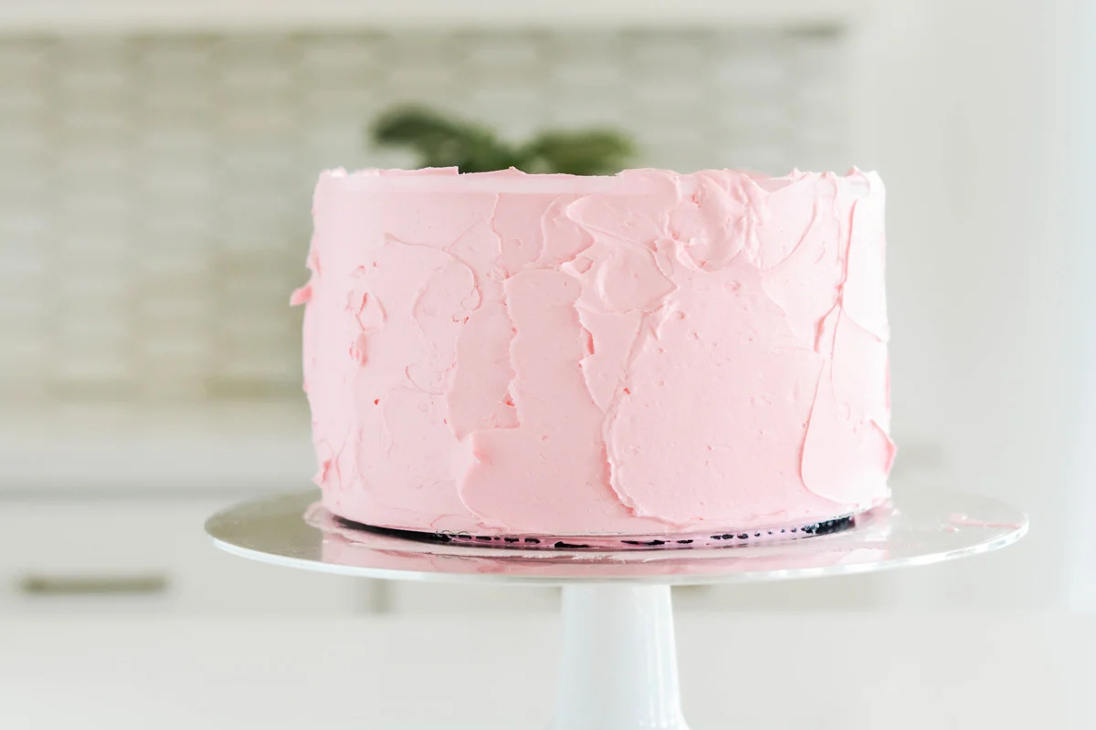 Vanilla Birthday Cake covered in pink frosting.