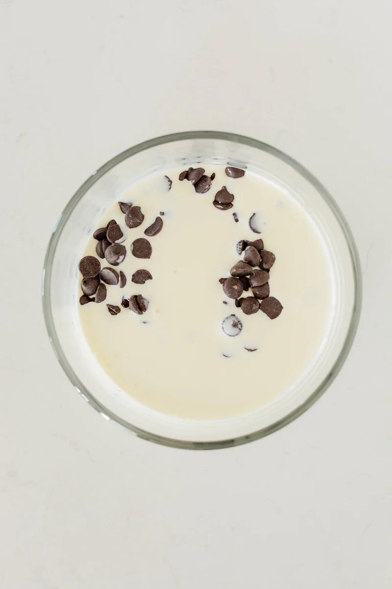 Overhead shot of dark chocolate chips and heavy cream for Devil’s Food Halloween Cake