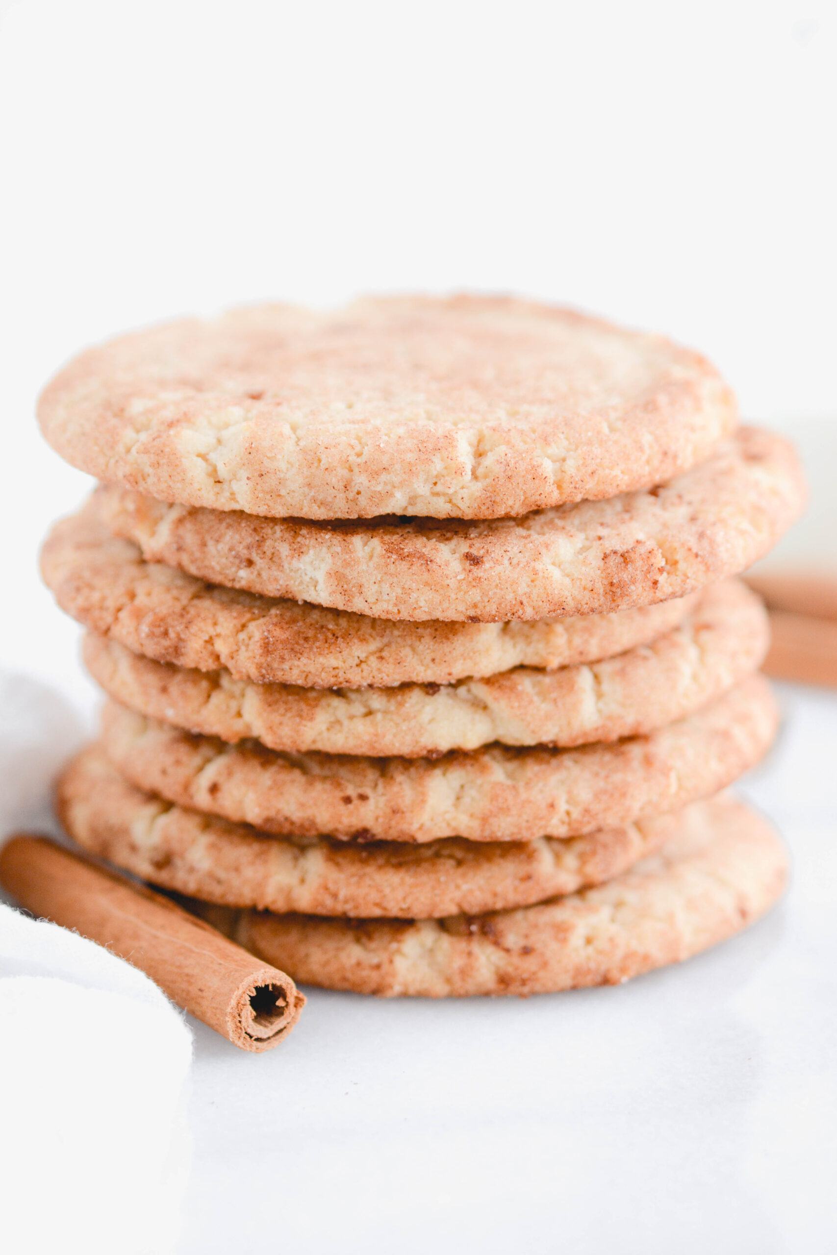 Snickerdoodles close up of stacked cookies with cinnamon stick.