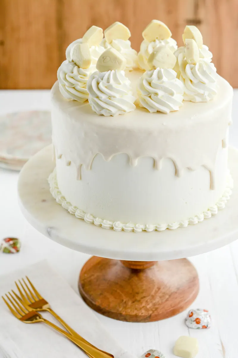 White Chocolate Pumpkin Cake on pedestal at three quarter angle.