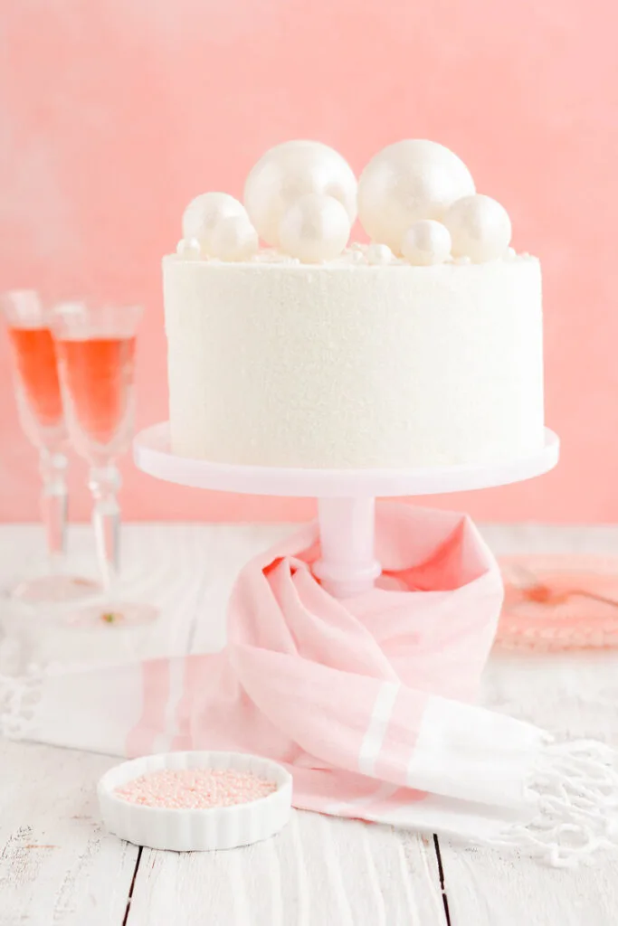 Pink Champagne Layer Cake on pink cake pedestal.