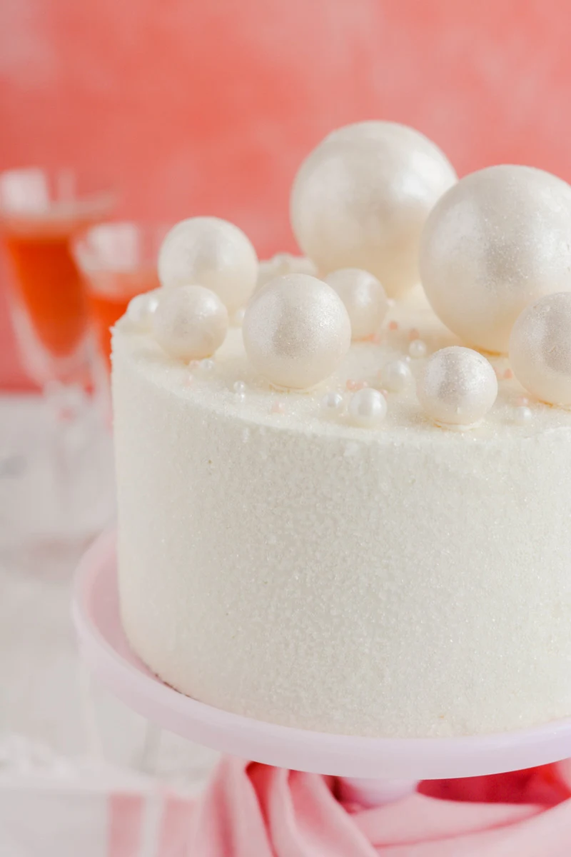 Close up of white chocolate spheres on top  of Pink Champagne Layer Cake.