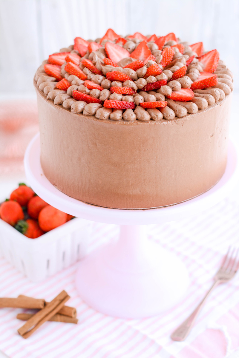 Three quarter angle of Strawberry Cinnamon Cake on pink cake pedestal.