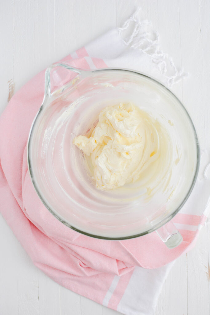 Overhead shot of beaten butter for cream cheese frosting for Valentine's Day Red Velvet Cake.