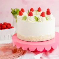 White Chocolate Raspberry Cake on pink cake pedestal.