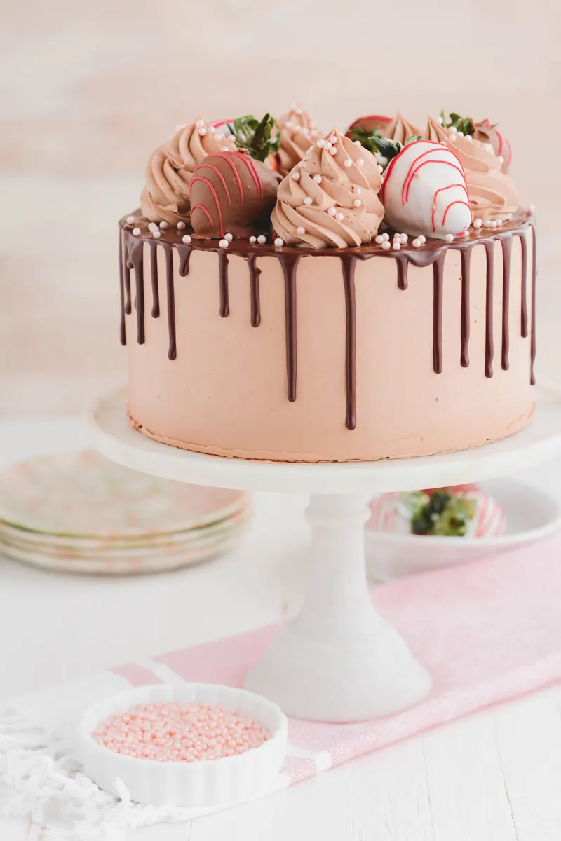 Top view of Pink heart shaped cake with chocolate glaze, meringues