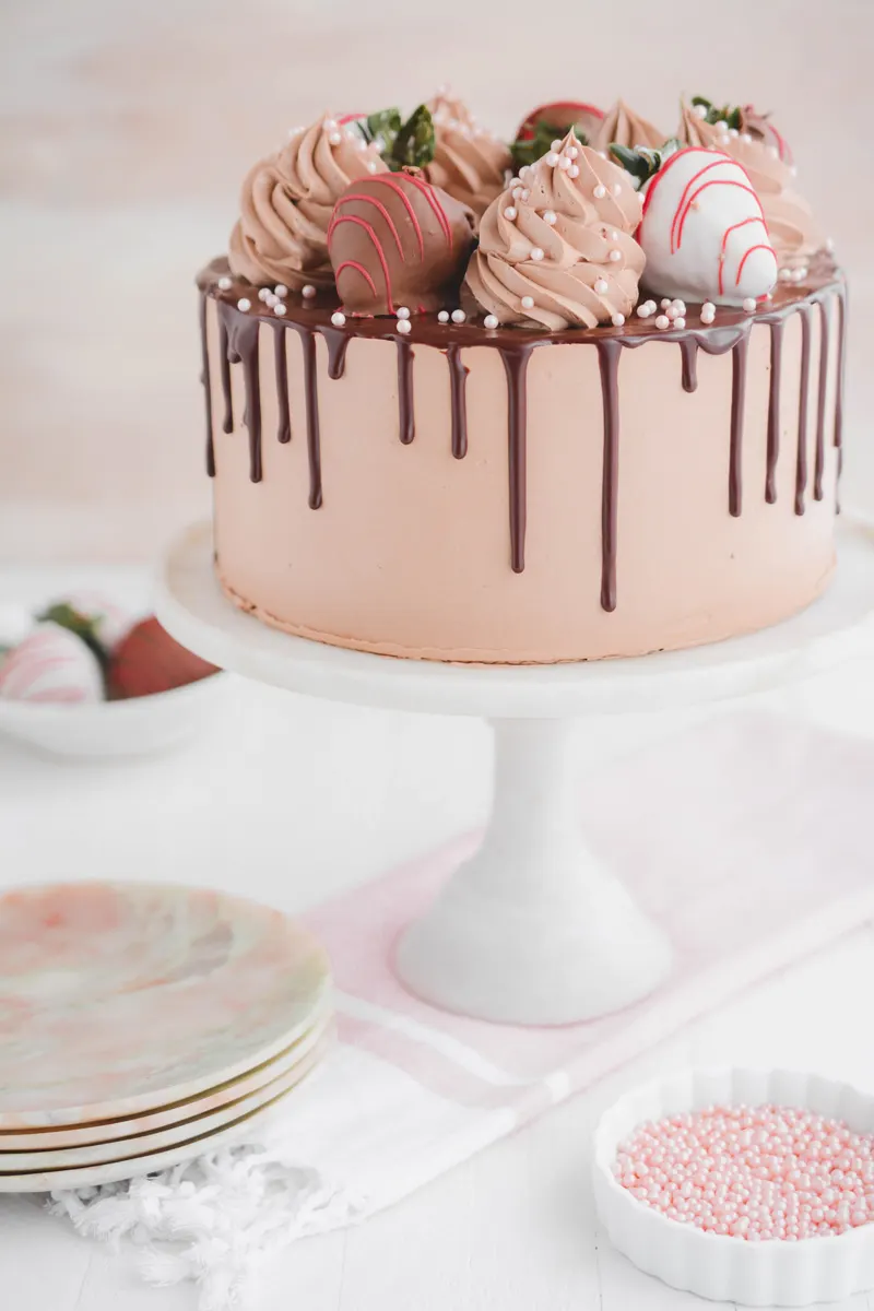 Off center angle of Chocolate Covered Strawberries Cake on Cake pedestal.