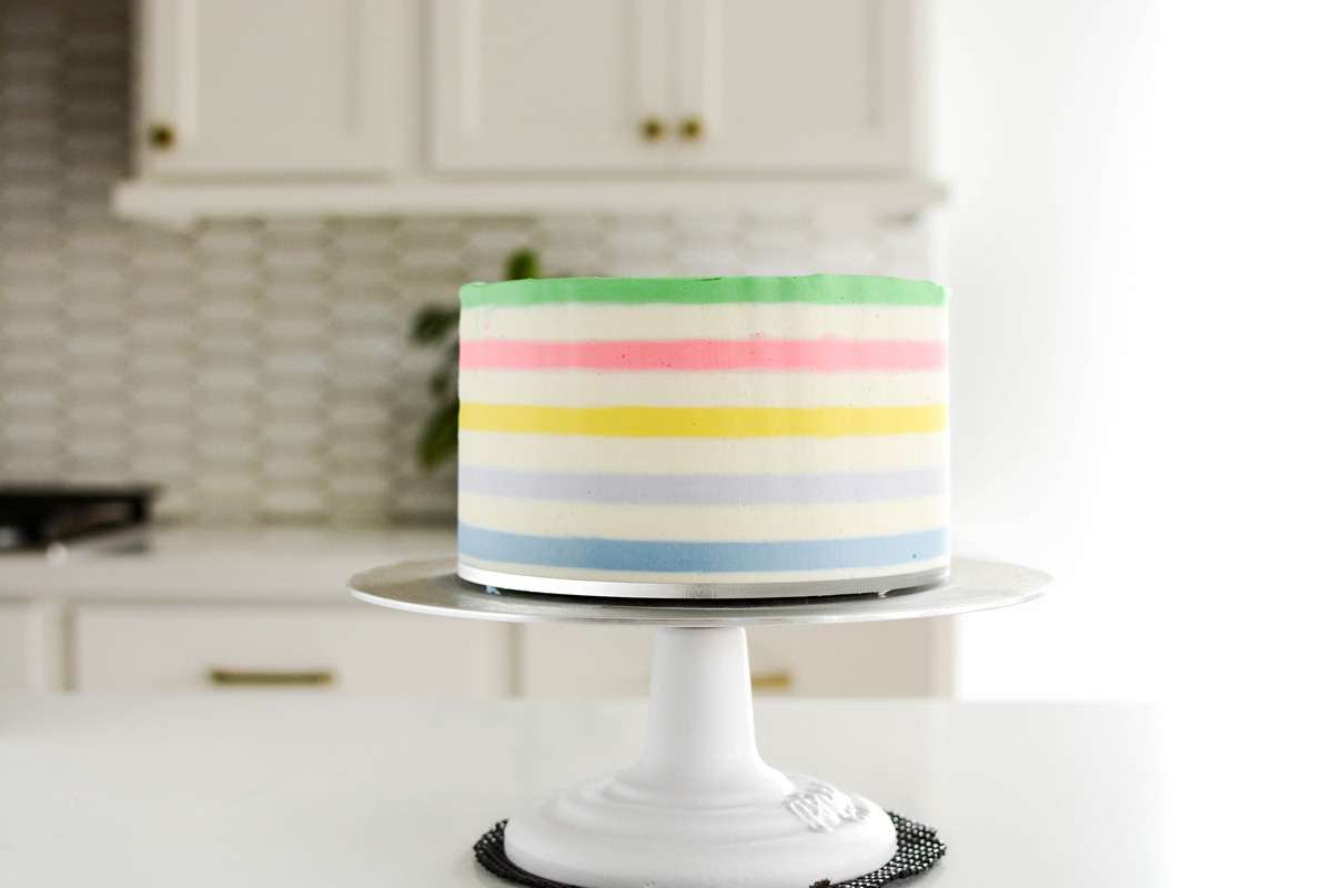 Lucky Charms Layer Cake with smoothed and completed colored frosting rows.