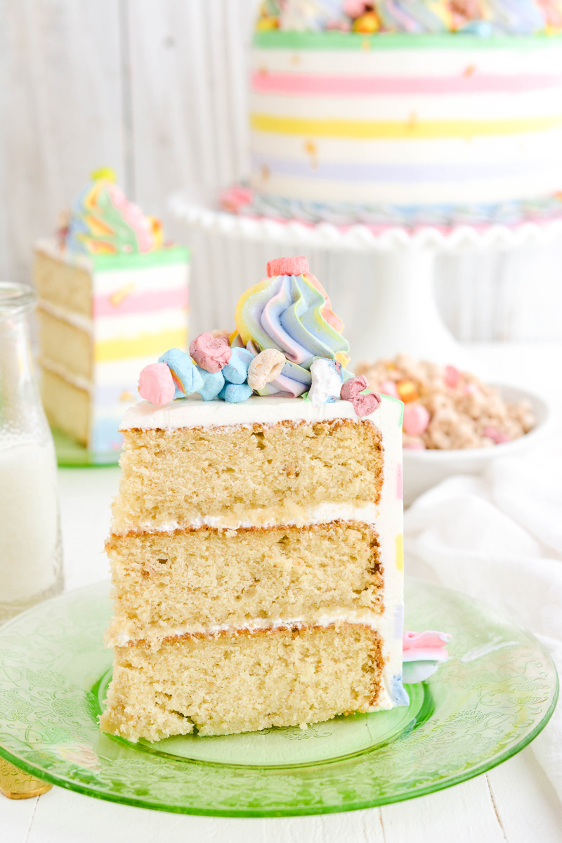 Close up of Lucky Charms Layer Cake sliced on green plate.
