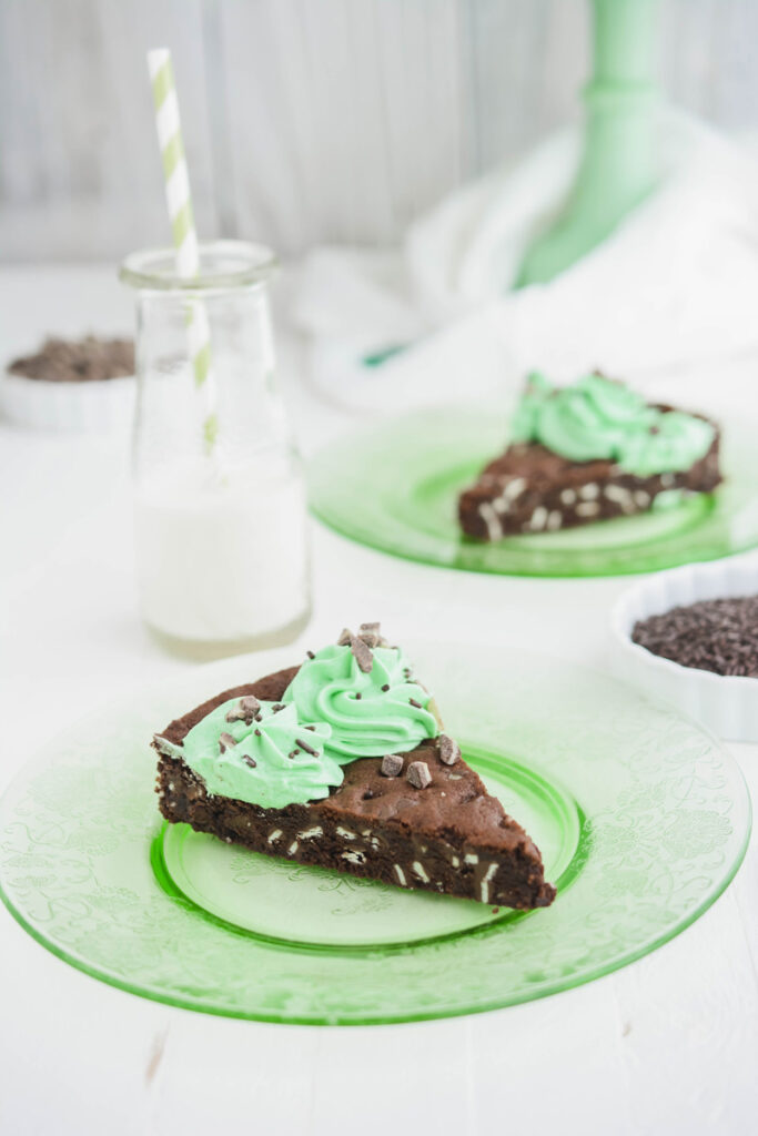 Mint Chocolate Chip Cookie Cake sliced on green plate.