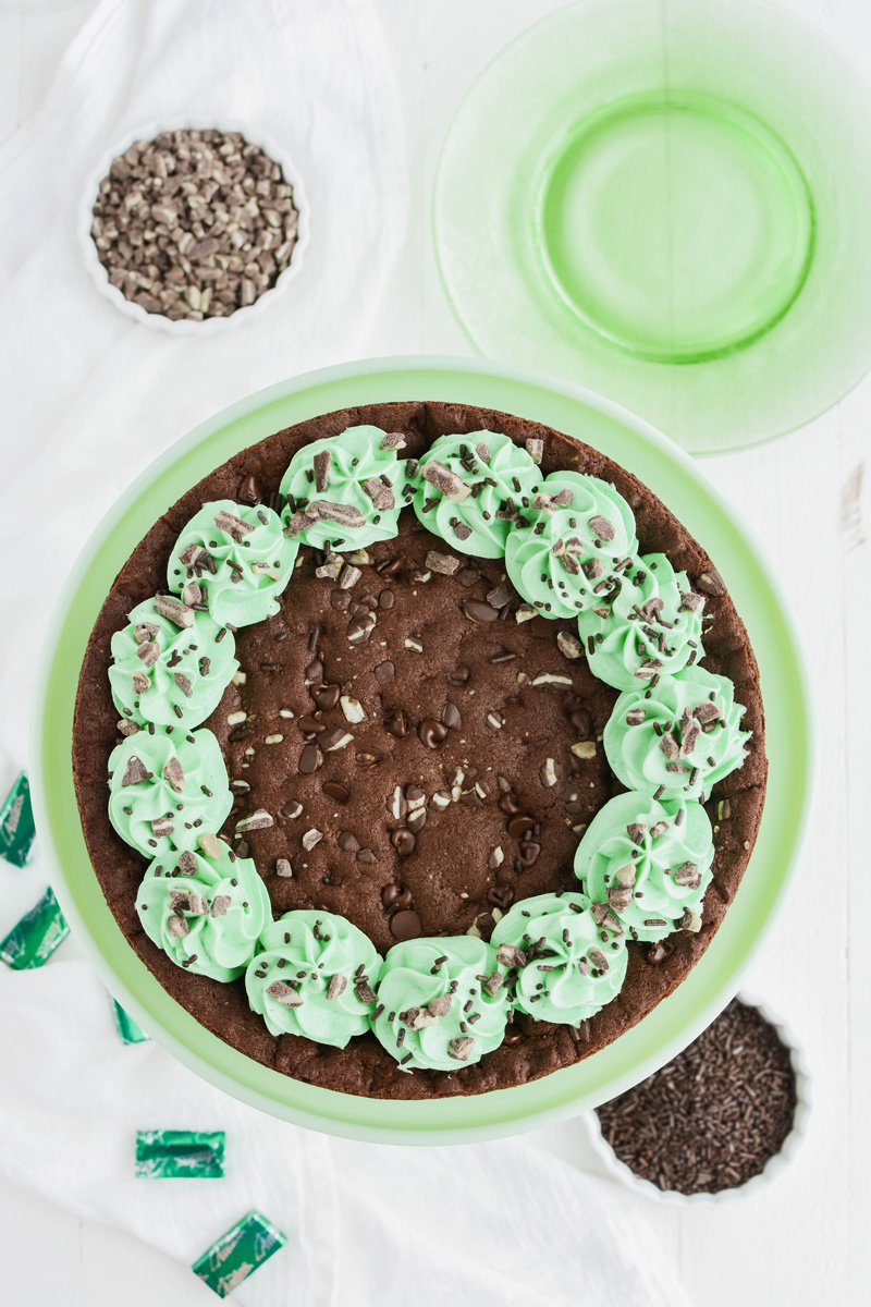 Overhead shot of Mint Chocolate Chip Cookie Cake on green cake pedestal.