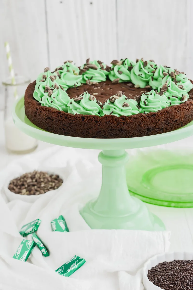 Close up shot of Mint Chocolate Chip Cookie Cake on green pedestal.