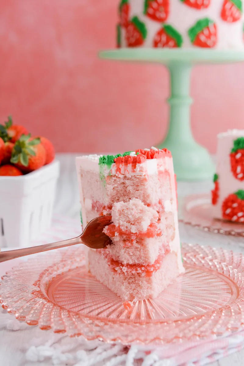 Close up of sliced Strawberry Patch Layer Cake with fork in the front.
