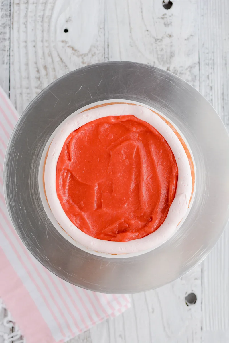 Overhead shot of frosting dam and filling for Strawberry Patch Layer Cake.