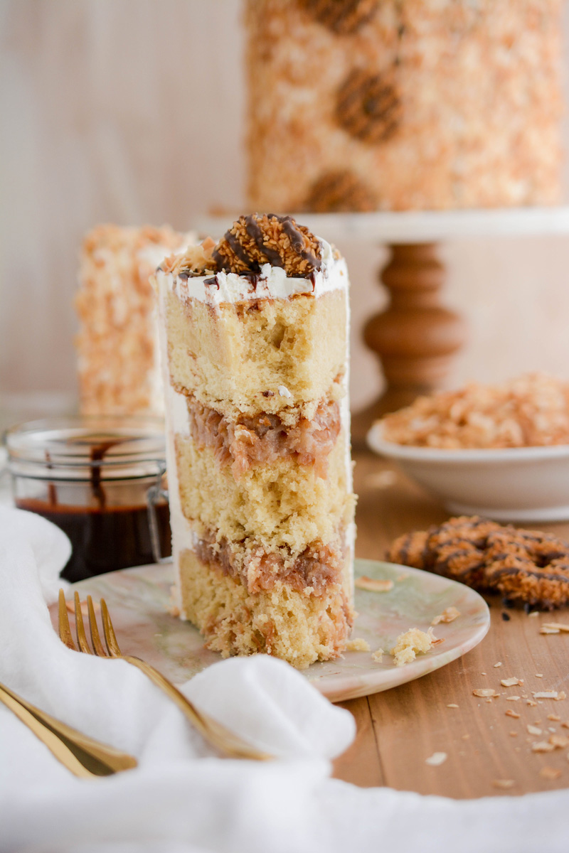 Close up of Toasted Coconut Caramel Cake sliced on marble plate.
