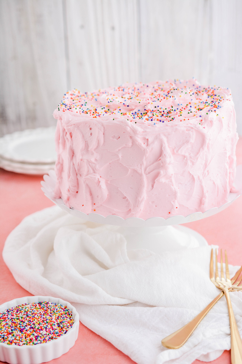 Mexican Pink Layer Cake on white cake pedestal.