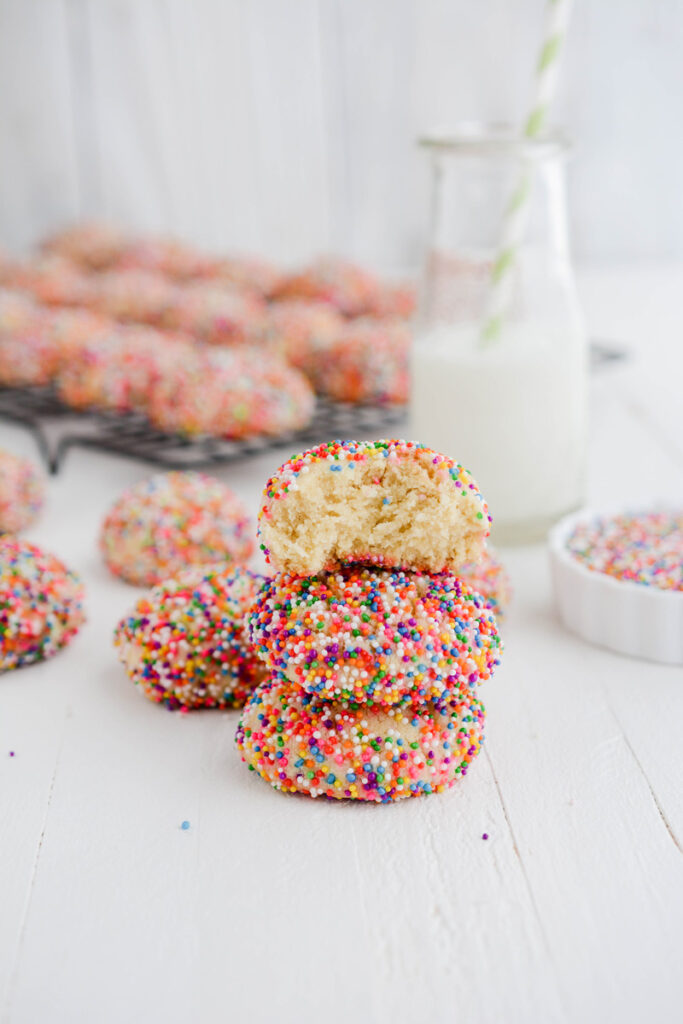 Stacked Mexican Sprinkle Cookies with one bite taken out.