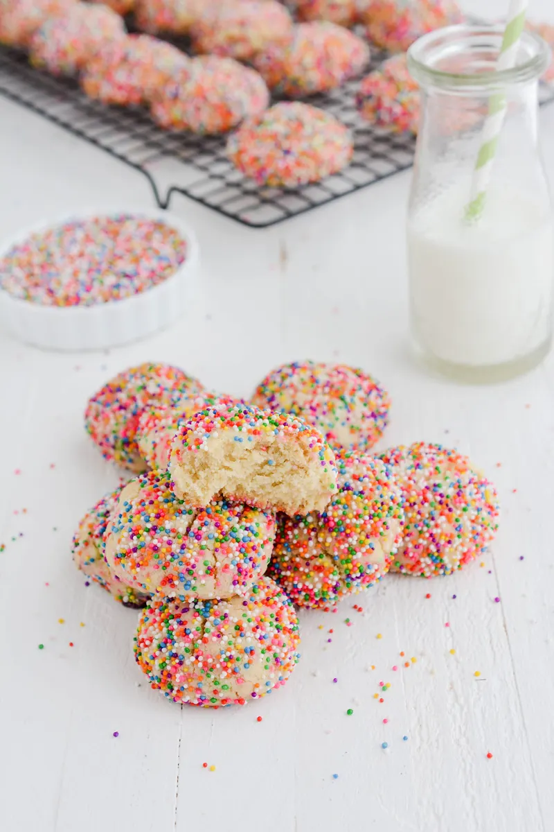 Three quarter angle shot of Mexican Sprinkle Cookies sitting in a pile.