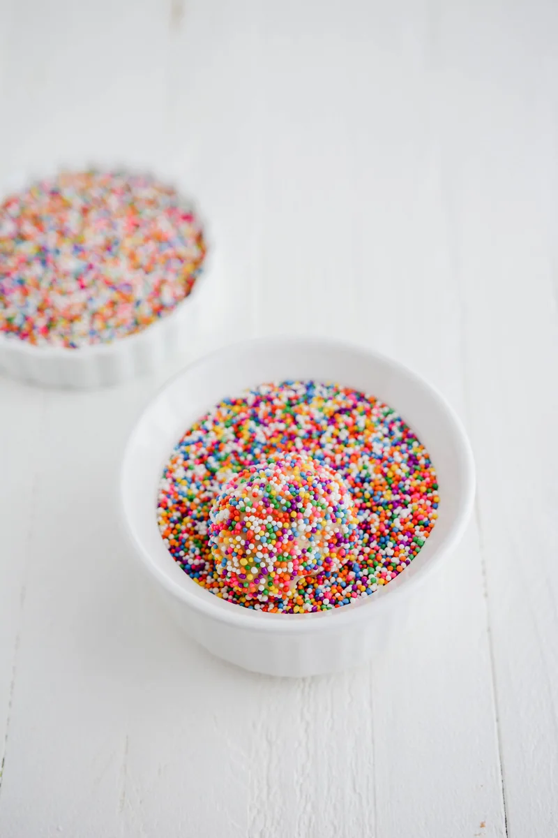Cookie dough ball covered in sprinkles for Mexican Sprinkle Cookies.