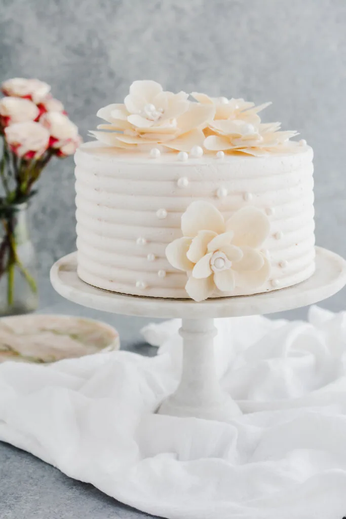 White Chocolate Rose Cake on marble cake pedestal.