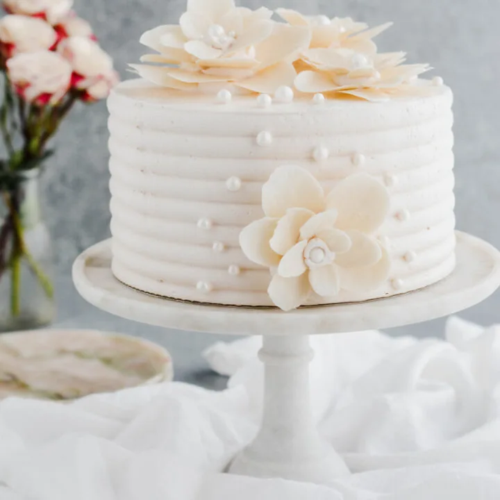 White Chocolate Rose Cake on marble cake pedestal.