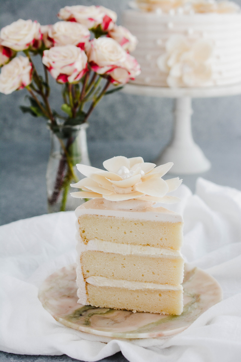 Close up of sliced White Chocolate Rose Cake on marble plate.