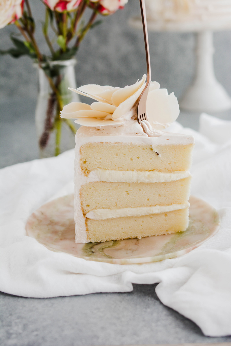 Close up of White Chocolate Rose Cake with fork pressing into it.