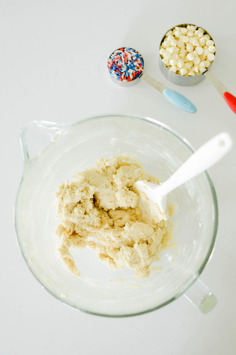 Cookie dough for July 4th Cookie Cake on glass mixing bowl.