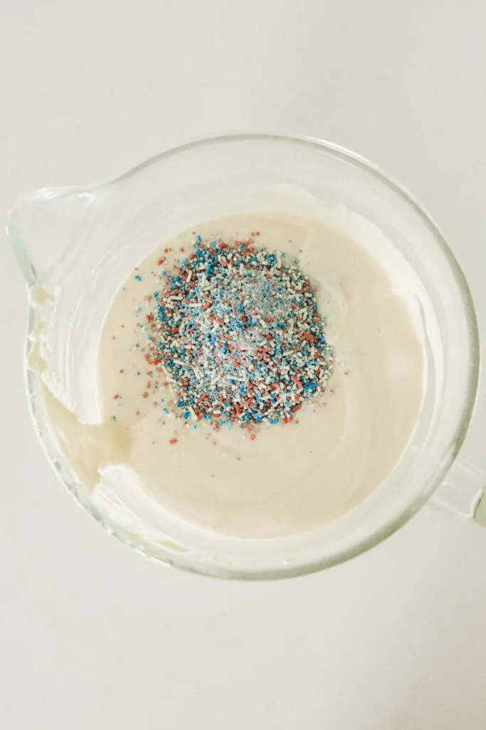 Overhead shot of completed cake batter with sprinkles added for Patriotic Confetti Cake.