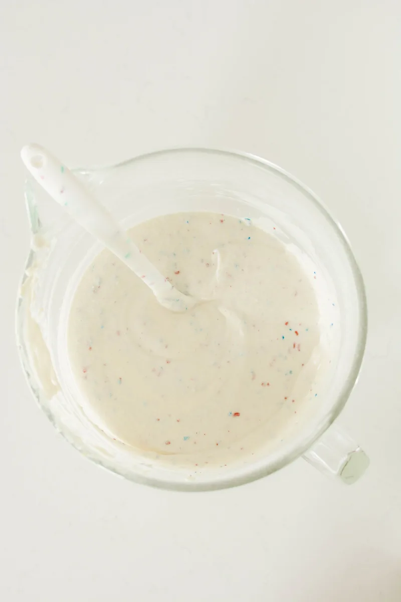 Overhead shot of completed cake batter with sprinkles for Patriotic Confetti Cupcakes.