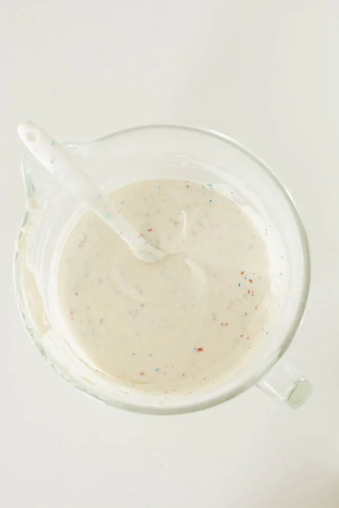 Overhead shot of completed cake batter with sprinkles mixed in for Patriotic Confetti Cake.