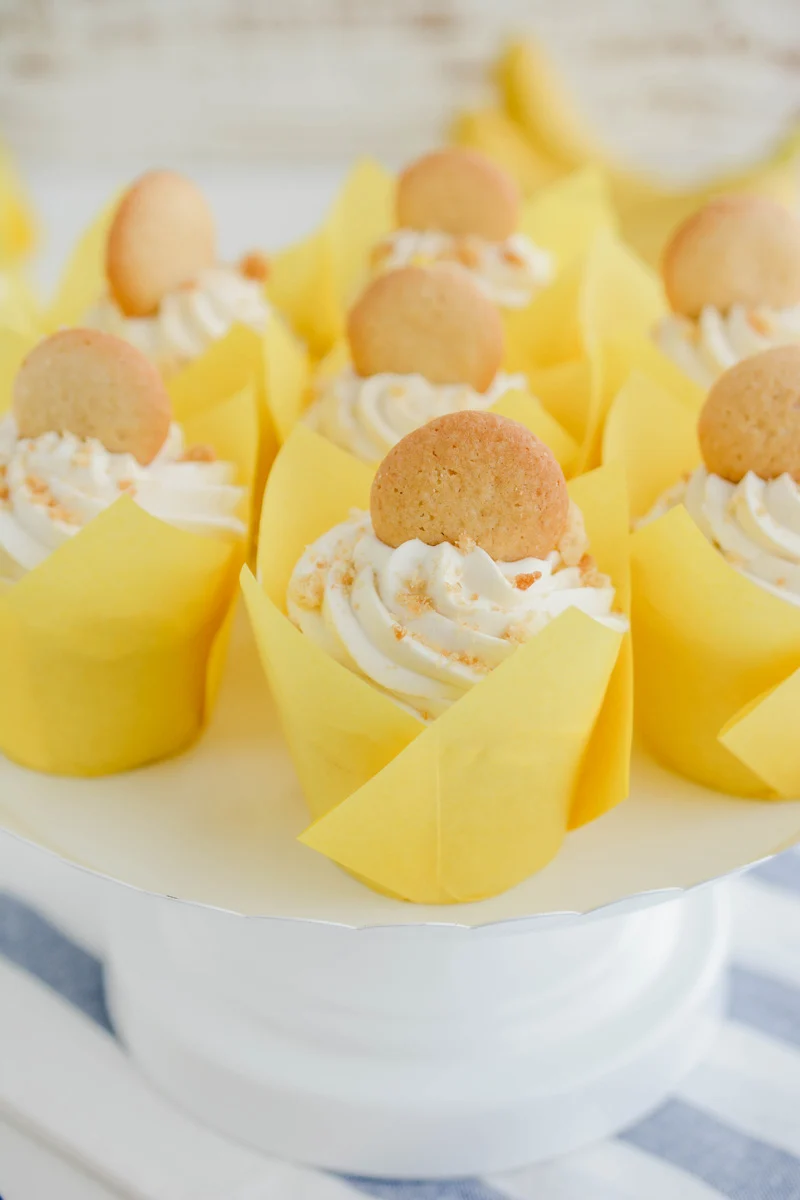 Three quarter angle of Banana Cream Pie Cupcakes on white cake pedestal.