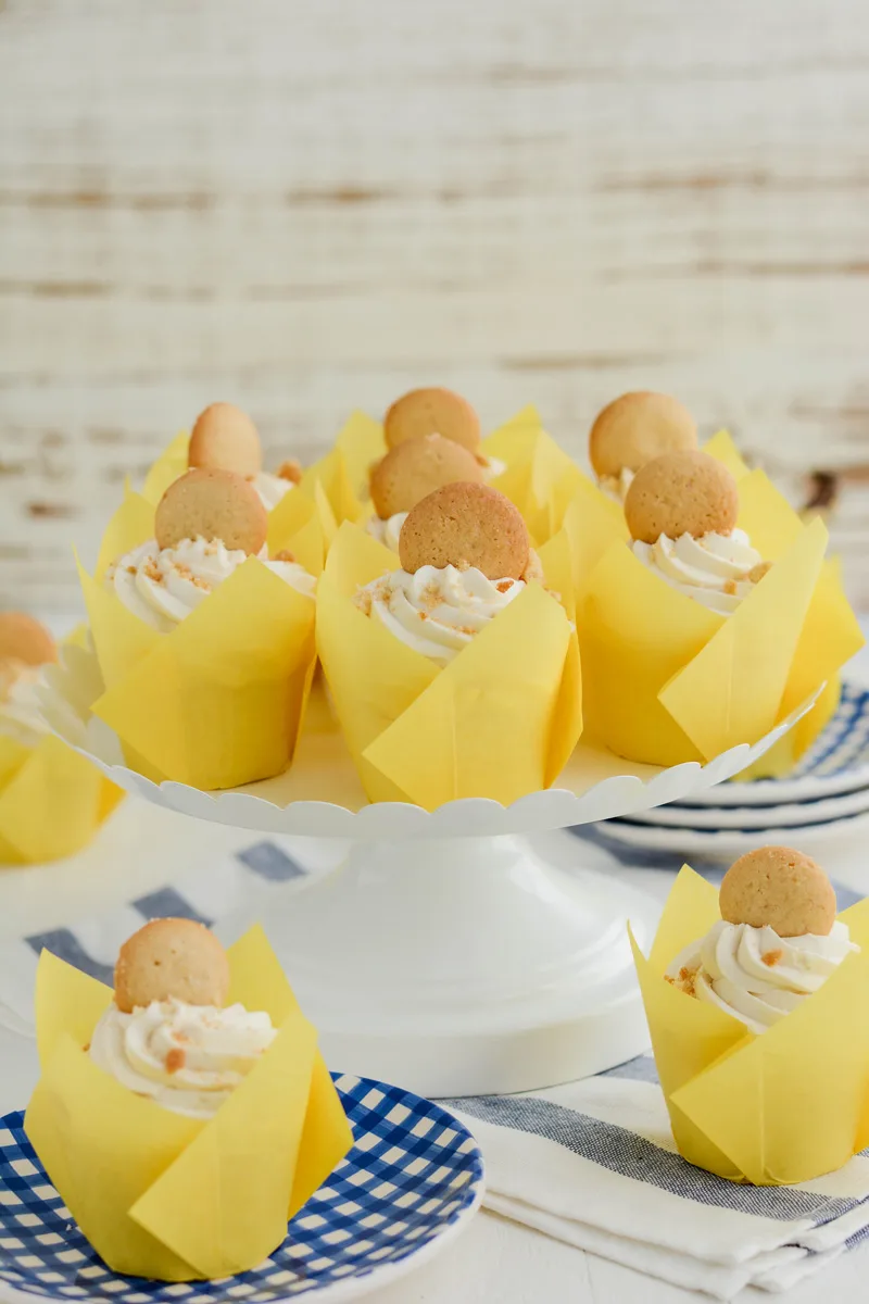 Wide open shot of Banana Cream Pie Cupcakes on white cake pedestal.