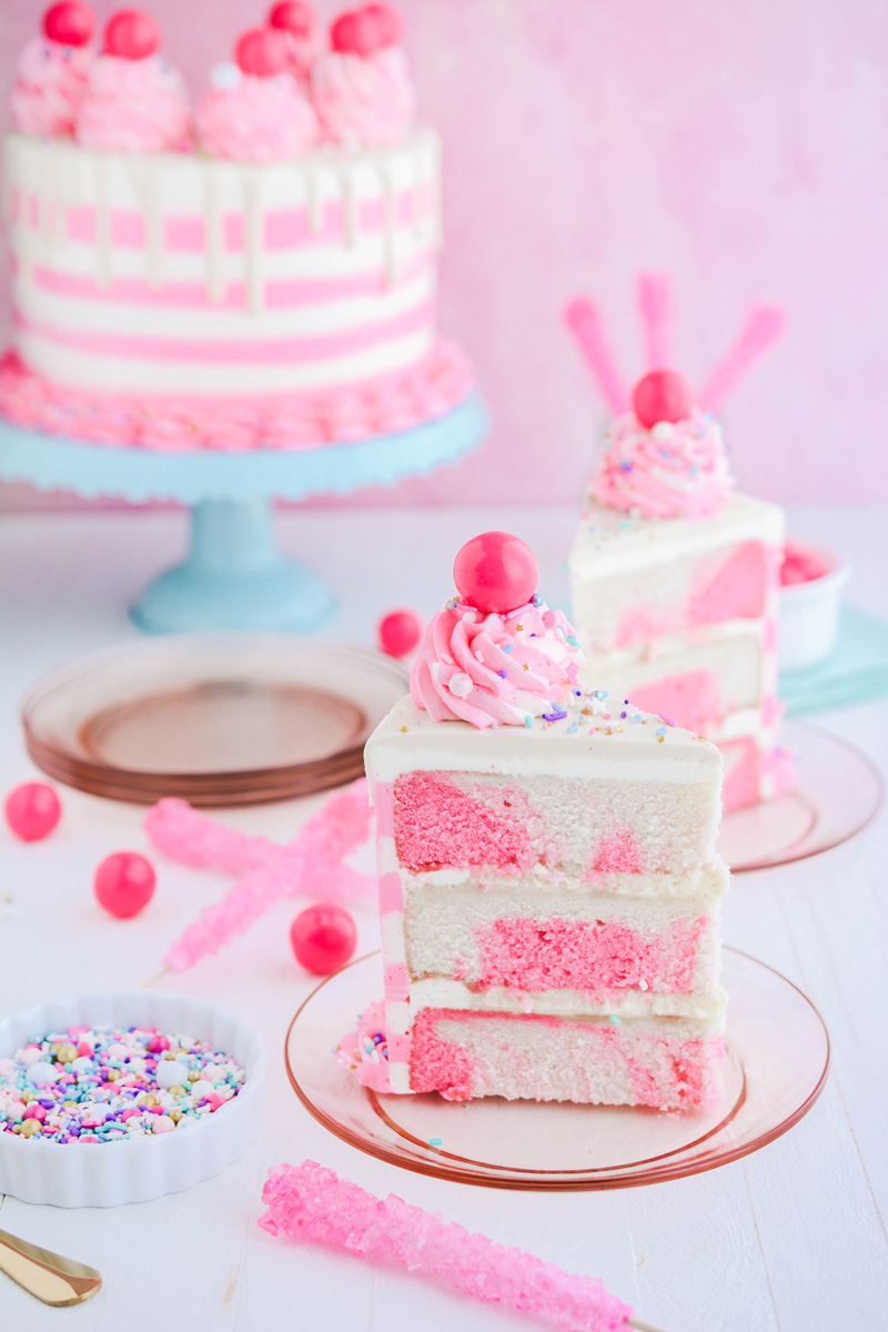 Wide open shot of Bubble Gum Layer Cake slices on pink plates.