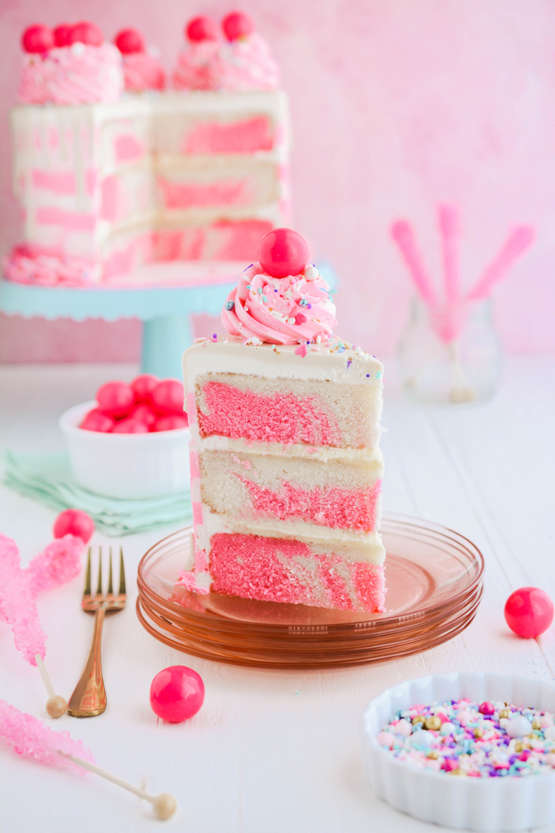 Sliced Bubble Gum Layer Cake on pink plate.