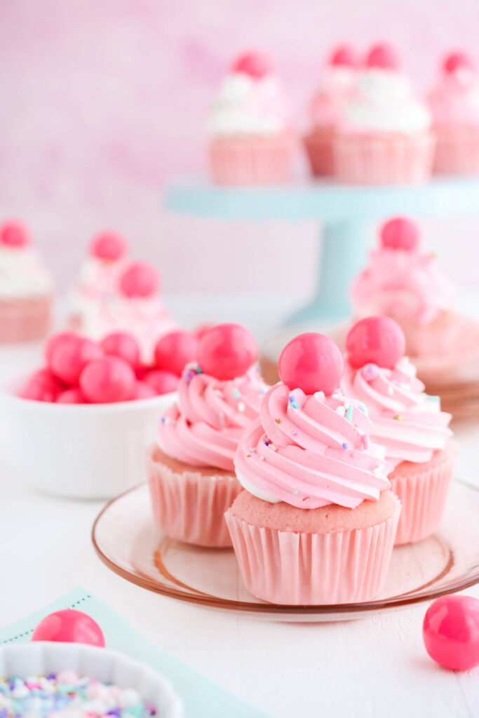 Close up of three Pink Bubble Gum Cupcakes on a pink plate.