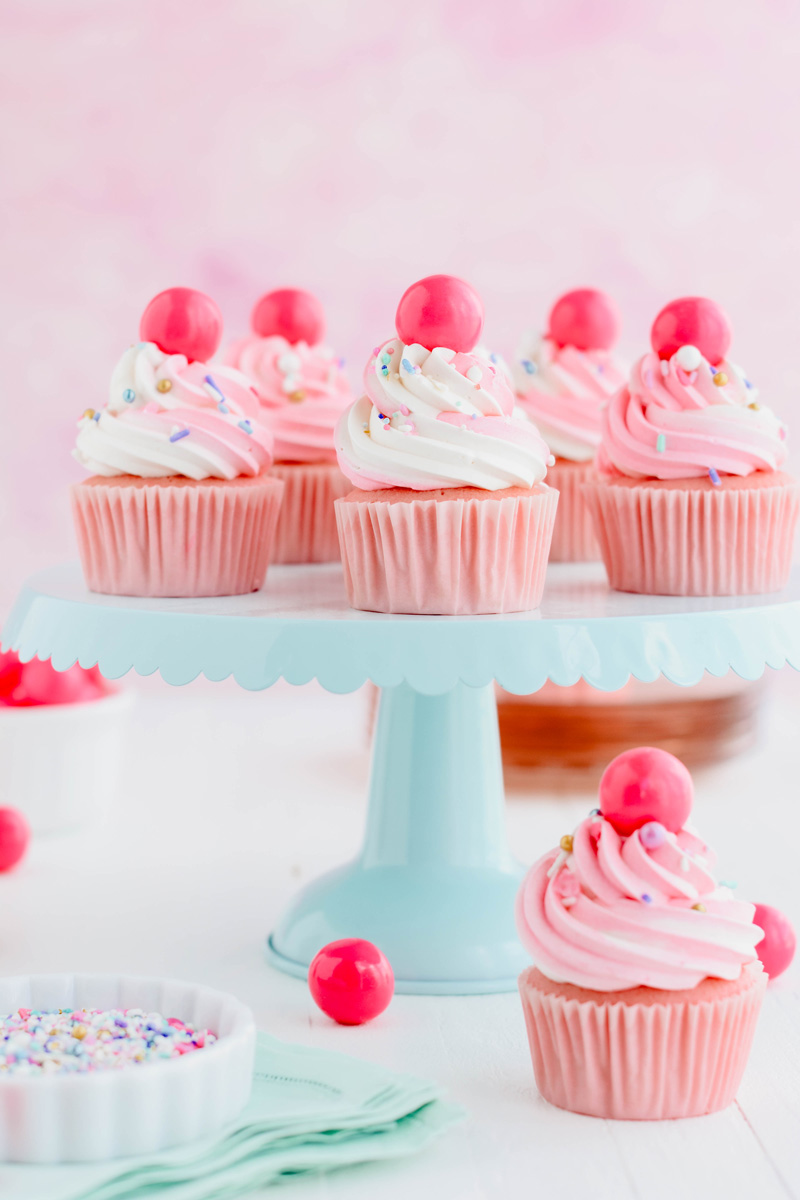 Pink Bubble Gum Cupcakes on teal cake pedestal.