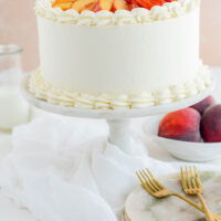 Peaches and Cream Layer Cake on marble cake pedestal.
