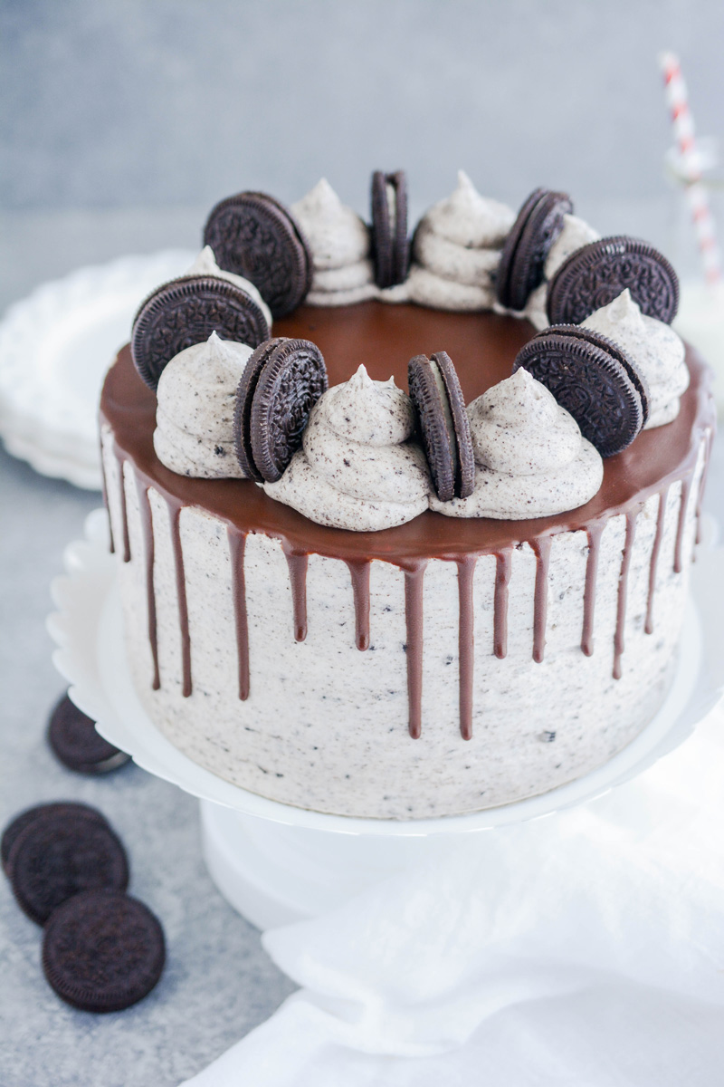 Ultimate Cookies and Cream Layer Cake at three quarter angle on white cake pedestal.
