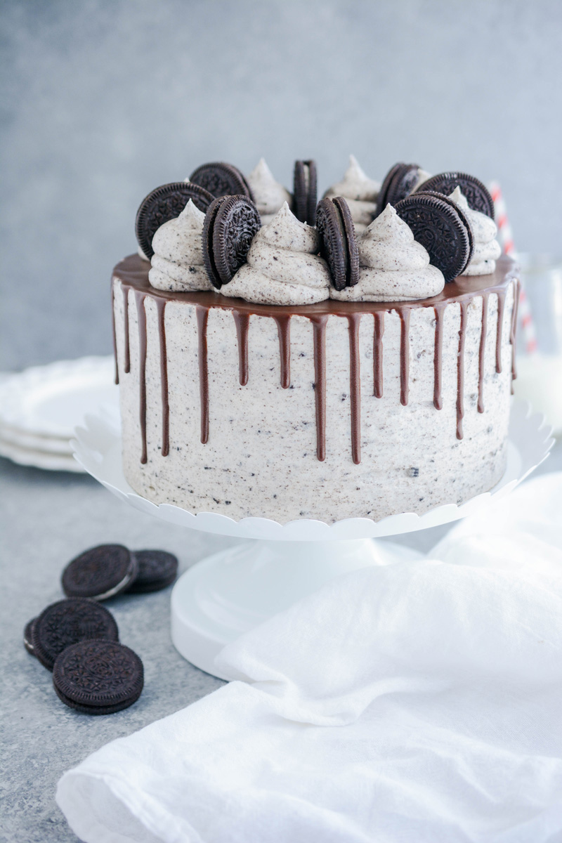 Ultimate Cookies and Cream Layer Cake on white cake pedestal.